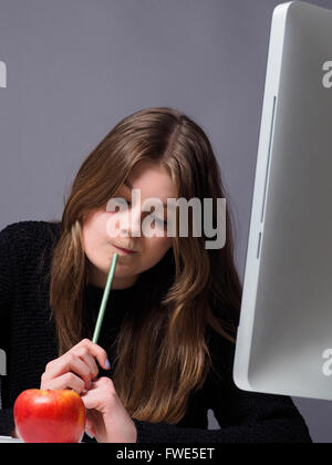 Belle jeune étudiante travaillant dans un bureau Banque D'Images