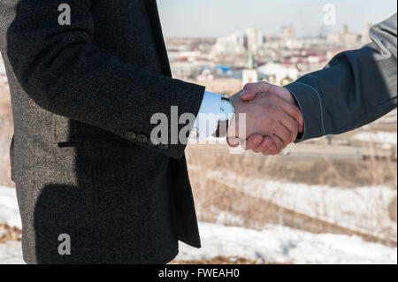 Travailleur de l'industrie gants avec serre la main de businessman Banque D'Images