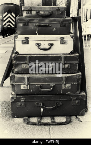 Pile de vieilles valises battues sur une gare ferroviaire de style vintage avec filtre appliqué à l'image Banque D'Images