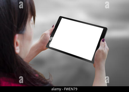 Tablette Noir avec blanc, blanc, écran isolé pour femme en maquette la main. La vie de la ville en arrière-plan. Banque D'Images