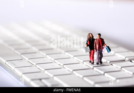 Online Shopping concept de droit d'un couple sur un clavier d'ordinateur carrying shopping bags Banque D'Images