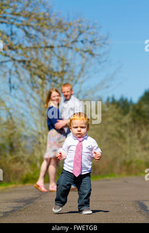 Les parents sont hors de l'attention, dans ce focus sélectif image pendant un petit garçon court vers l'appareil photo. Banque D'Images