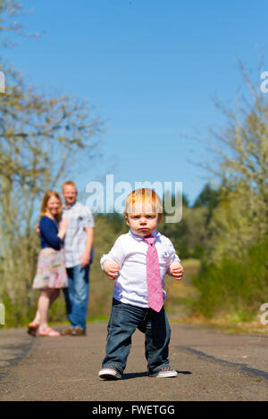 Les parents sont hors de l'attention, dans ce focus sélectif image pendant un petit garçon court vers l'appareil photo. Banque D'Images