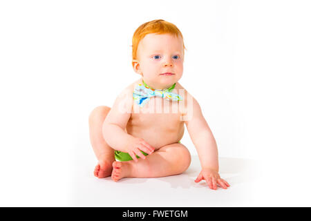 Un petit garçon âgé d'un an dans le studio avec un fond blanc. L'enfant porte un nœud papillon et une couche. Banque D'Images