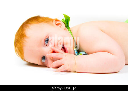 Un mignon petit garçon âgé d'un an fixe en studio sur un fond blanc à la mignon et heureux. Banque D'Images