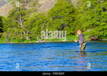 Un pêcheur de mouche patauge dans l'eau tandis que la pêche à la mouche la rivière Deschutes dans l'Oregon. Banque D'Images