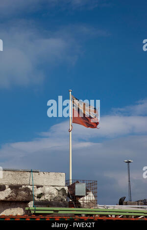 Un vitrail en lambeaux et Union Jack drapeau flotte dans la brise sur le quai à Whitby Harbour sur la côte du Yorkshire Banque D'Images