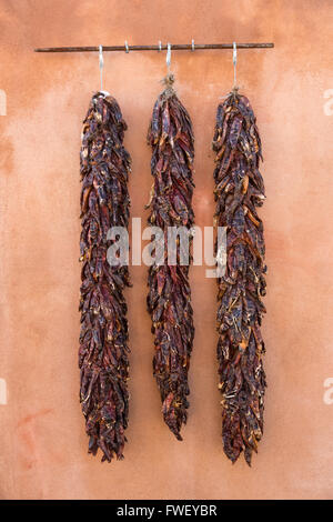 Piment séché ristras accrocher sur un mur d'adobe dans la vieille ville Plaza 14 décembre 2015, à Albuquerque, Nouveau Mexique. Banque D'Images