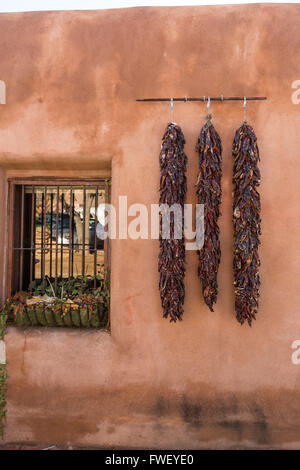 Piment séché ristras accrocher sur un mur d'adobe dans la vieille ville Plaza 14 décembre 2015, à Albuquerque, Nouveau Mexique. Banque D'Images