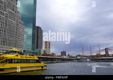 Taxi de l'eau au quai 11 avec la toile de gratte-ciel de Manhattan et le pont de Brooklyn, New York, NY, USA Banque D'Images