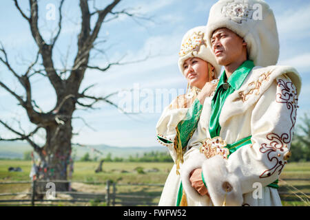 Couple en costume traditionnel, sur fond de l'epic vieil arbre au milieu du paysage rural. Banque D'Images