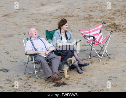 Vieux couple avec chien sur la plage. Homme endormi. Angleterre, Royaume-Uni Banque D'Images