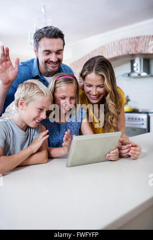 Parents et enfants using digital tablet in kitchen Banque D'Images