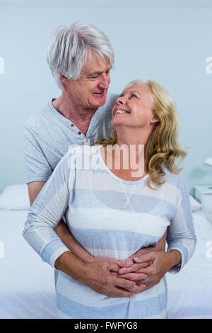 Happy senior couple hugging in bedroom Banque D'Images