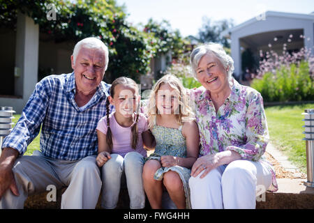 Les grands-parents-enfants assis dans le jardin Banque D'Images