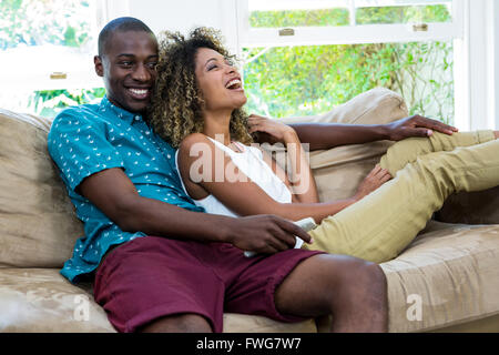Happy young couple watching television Banque D'Images