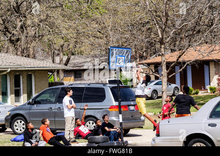 Ados et pré-adolescents se rassembler et jouer au basket-ball dans la rue à Oklahoma City, Oklahoma, USA. Banque D'Images
