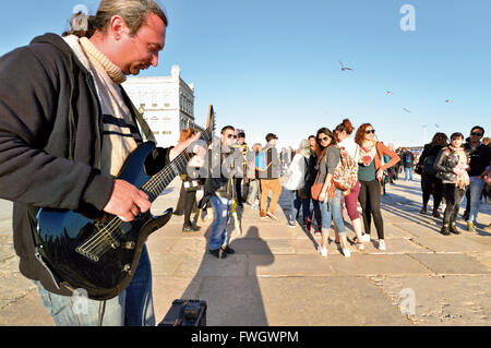 Portugal, Lisbonne : Street musician playing electric guitar pour un groupe de jeunes touristes Banque D'Images