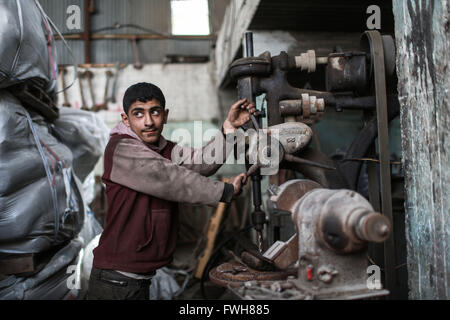 La bande de Gaza. 5ème apr 2016. Garçon palestinien Salah Dalloul, 13 ans, qui travaille comme mécanicien pour aider son père à l'appui de leur famille, est vu dans un garage dans la ville de Gaza le 5 avril 2016. De nombreux jeunes garçons palestiniens essaient de gagner leur vie et soutenir leur famille. © Wissam Nassar/Xinhua/Alamy Live News Banque D'Images