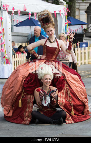 Trafalgar Square, Londres, 12 juin 2016. La pluie salue les Londoniens et les visiteurs de la capitale le Trafalgar Square comme le maire organise un déjeuner du patron en célébration de la Reine pour le 90ème anniversaire. Sur la photo : deux femmes en costume de poser pour des photos. Crédit : Paul Davey/Alamy Live News Banque D'Images