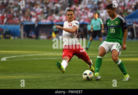 Arkadiusz Milik (L) de Pologne et Oliver Norwood (R) de l'Irlande du défi pour la balle pendant l'UEFA Euro 2016 football match du groupe C entre la Pologne et l'Irlande du Nord à Nice, France, le 12 juin 2016. Photo : Federico Gambarini/dpa Banque D'Images