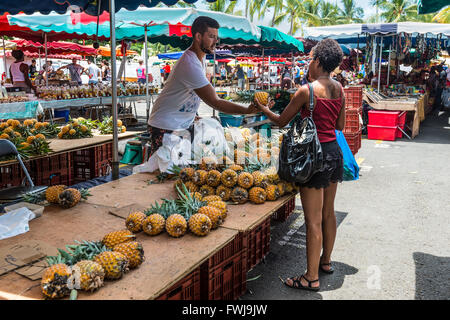 Fruits frais du vendeur l'ananas sur un marché local à saint Paul sur l'île de La Réunion (France) Banque D'Images