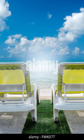 Deux chaises de plage sur la plage avec ciel bleu. Banque D'Images