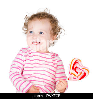 Cute girl bouclés avec un bonbon en forme de coeur, isolated on white Banque D'Images