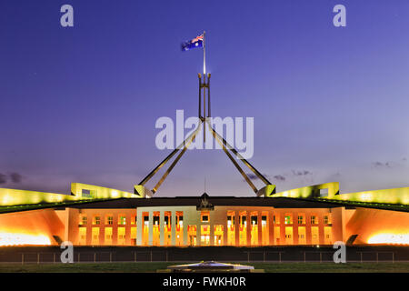 La construction du Parlement sur la colline du Capitole à Canberra - façade, entrée privée et colonnes illuminées avec grand mât et mât sur le Banque D'Images
