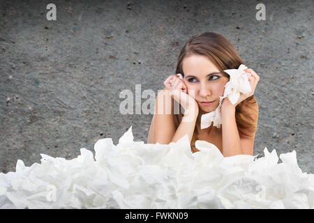 Femme malade avec beaucoup de hankys sur le mur gris Banque D'Images