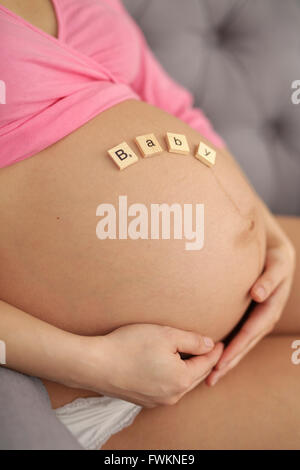 Ventre d'une femme enceinte avec des lettres Banque D'Images