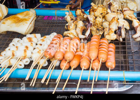 Les saucisses et les calmars sur une barbecueing street food à Bangkok, Thaïlande Banque D'Images