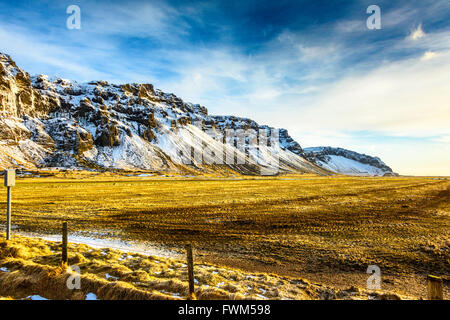 Paysages d'hiver islandais au lever du soleil, baignant la terre de lumière dorée Banque D'Images