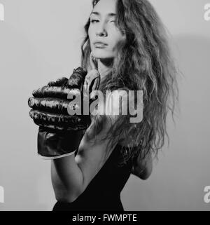 Portrait de jeune femme habillée en tenue de soirée et des gants de boxe Banque D'Images