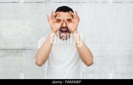 Man making collés sur les lunettes arrière-plan gris Banque D'Images