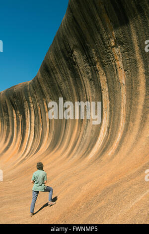 Femme et Wave Rock, suppression de la formation de granit, l'ouest de l'Australie Banque D'Images