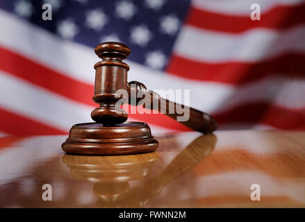 En bois acajou gavel sur table en bois brillant, USA drapeau dans l'arrière-plan. Banque D'Images