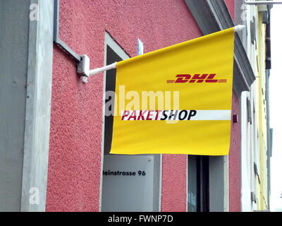 Cologne, Allemagne. 4ème apr 2016. Le drapeau arborant le logo du service de livraison de courrier DHL se joint à l'entrée au-dessus d'une boutique colis DHL à Cologne, Allemagne, 4 avril 2016. Photo : Horst Galuschka/DPA - PAS DE FIL - SERVICE/dpa/Alamy Live News Banque D'Images