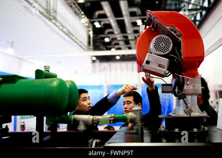 (160406) -- BEIJING, 6 avril 2016 (Xinhua) -- les visiteurs à connaître un appareil à faible taux d'émission à la huitième exposition de l'industrie à faible émission de carbone de la Chine s'est tenue à Beijing, Chine, le 6 avril 2016. Les 3 jours de l'événement a attiré près de 1 000 entreprises et quelque 5000 produits avec de nouvelles technologies, de concentrer l'industrie à faible émission de carbone. (Xinhua/Pan Xu) (ZHS) Banque D'Images