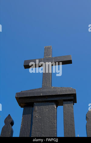 Petit crucifix en bois contre un ciel bleu clair Banque D'Images