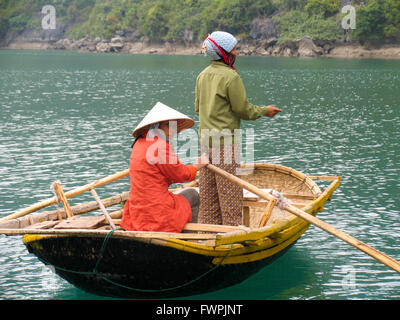 Deux femmes de la pêche une canne bateau dans la baie d'Halong, Vietnam. Banque D'Images