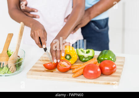 Femme couper des légumes sur planche à découper Banque D'Images