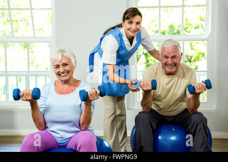 Portrait of smiling nurse assisting senior man and woman Banque D'Images