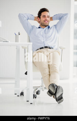 Portrait avec les mains derrière la tête dans le bureau Banque D'Images