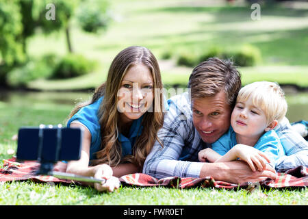 Les parents et les fils en tenant un téléphone mobile sur selfies Banque D'Images