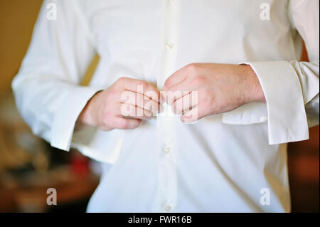 Marié à matin porte une chemise blanche pour mariage Banque D'Images