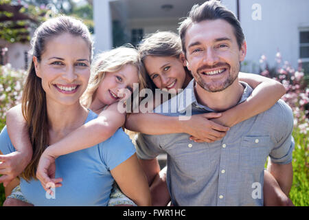 Portrait de parents donnant un piggy back pour filles Banque D'Images