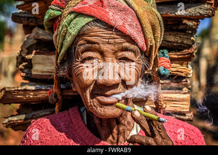 Vieille Femme ridée fume un cigare cheroot Banque D'Images