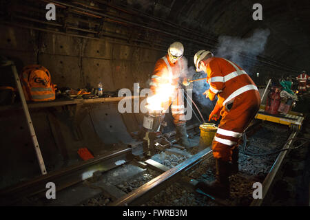 Souder les composants de la voie de remplacement ingénieurs ensemble à l'aide de soudure aluminothermique sur London Underground rail track, Londres, UK Banque D'Images