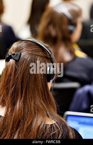 Les gens d'affaires de l'utilisation des écouteurs méconnaissable pour la traduction pendant l'événement Banque D'Images